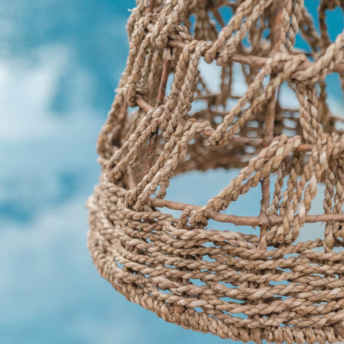 Gedetailleerde close-up van het handgemaakte zeegras hanglamp vlechtwerk.